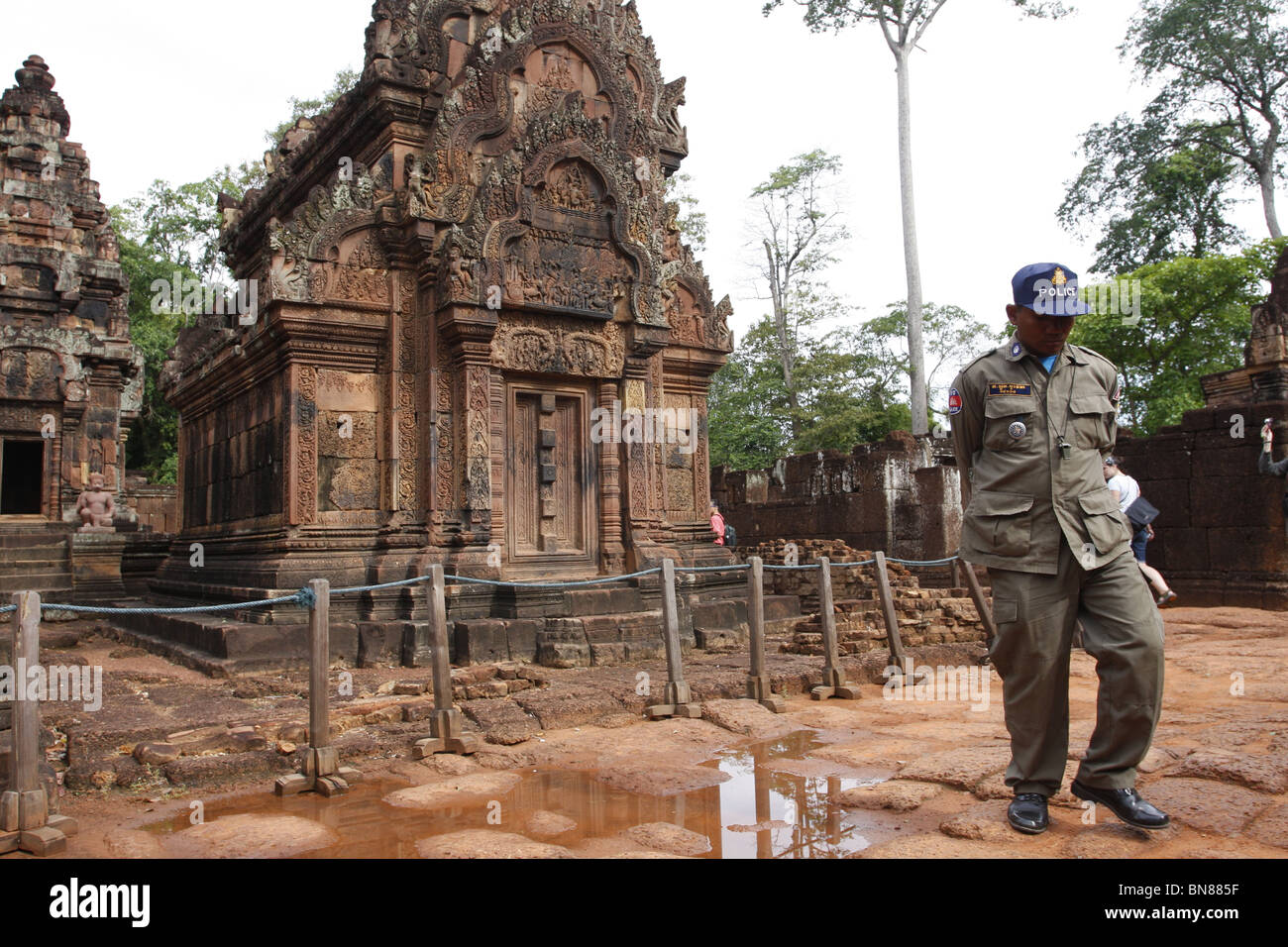 Un uomo di polizia nel cortile interno di Banteay Srei, Angkor, Cambogia Foto Stock