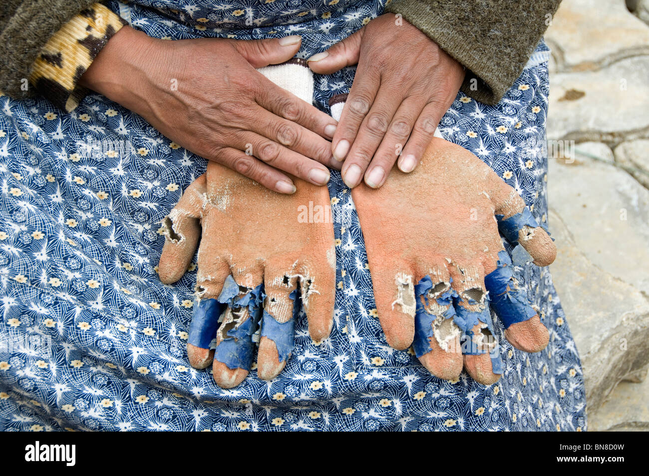 El Alto. La donna costruttore di strada mostra la usurata guanti che indossa come scarsa protezione per lavori pesanti Foto Stock