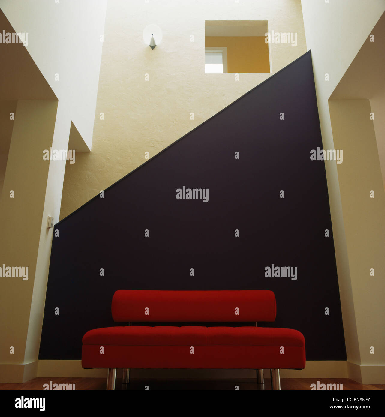 Divano rosso porpora contro la parete geometrica nel soggiorno moderno Foto  stock - Alamy