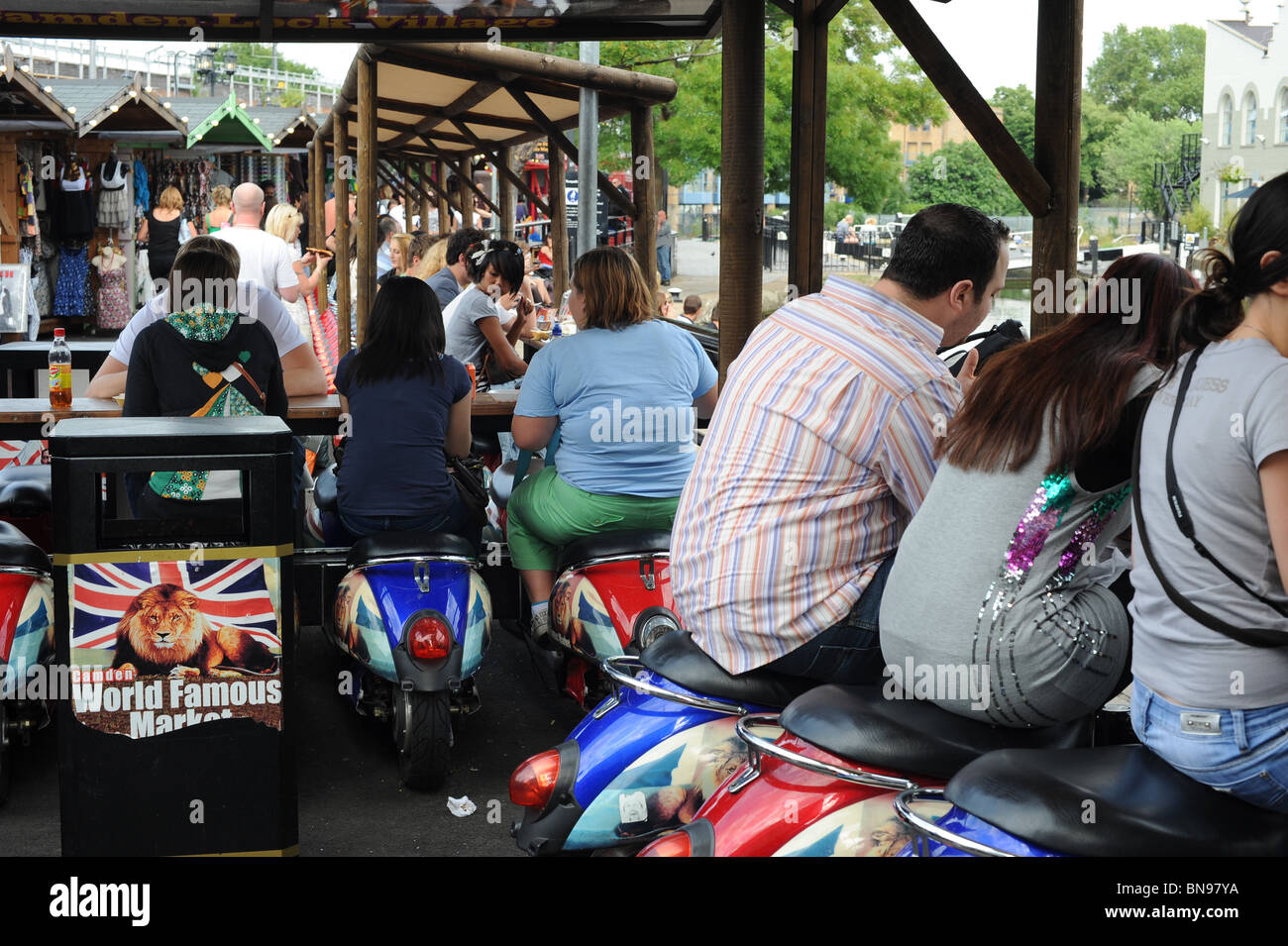 Scooter colorata utilizzata per posti a sedere vicino a banchi di cibo nella sezione più recente del mercato di Camden. Nel nord di Londra Foto Stock
