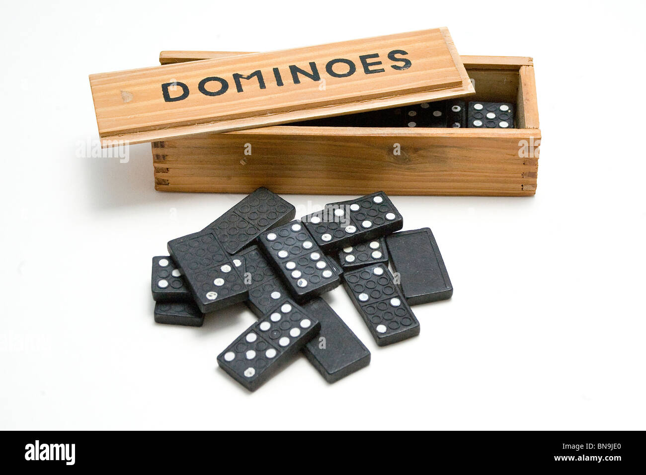 Vintage scatola di legno riempita con Domino e domino disperse fino al di fuori Foto Stock