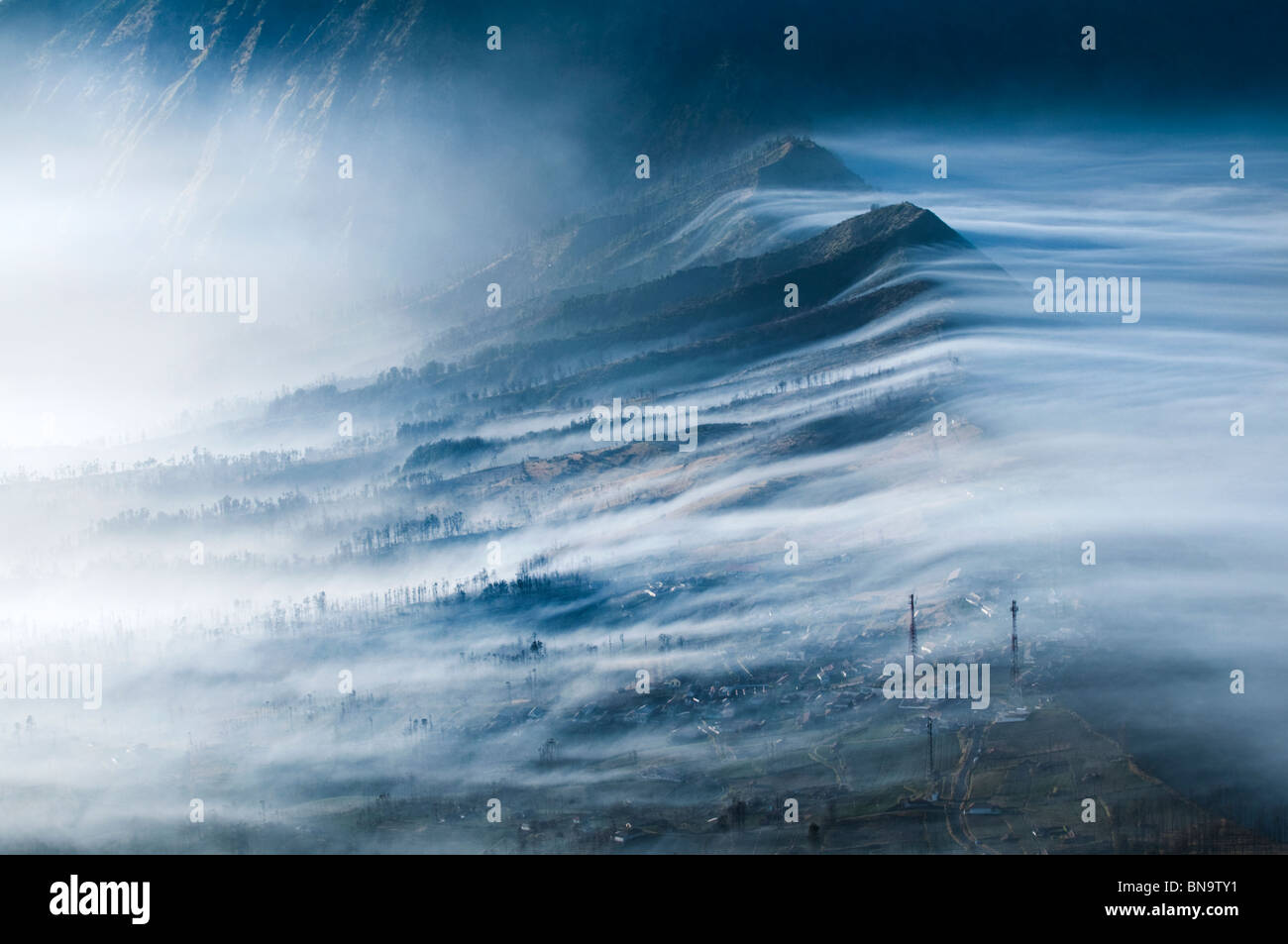 La nebbia che fluisce oltre Cemoro Lawang e nel cratere Gunung Bromo o Monte Bromo area Indonesia Java. Foto Stock
