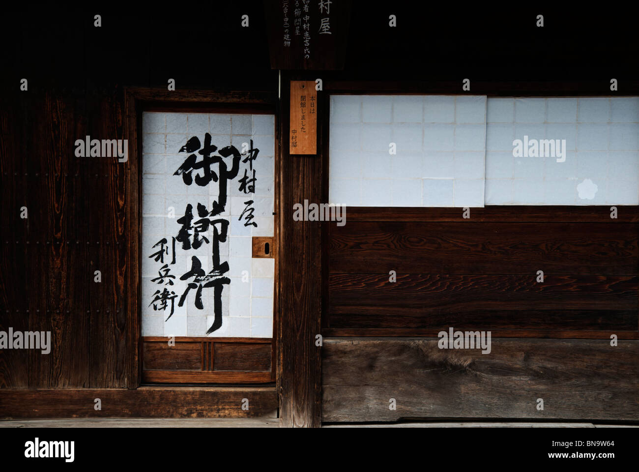 Un shoji tappezzato di porte e finestre in legno scuro e pareti di una casa lungo il Nakasendo in Narai-juku. Foto Stock