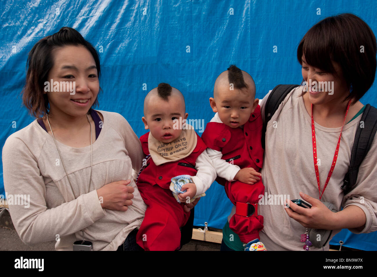 Due giovani madri giapponesi con le loro identicamente in piega e vestito i neonati durante il Festival di Onbashira. Foto Stock