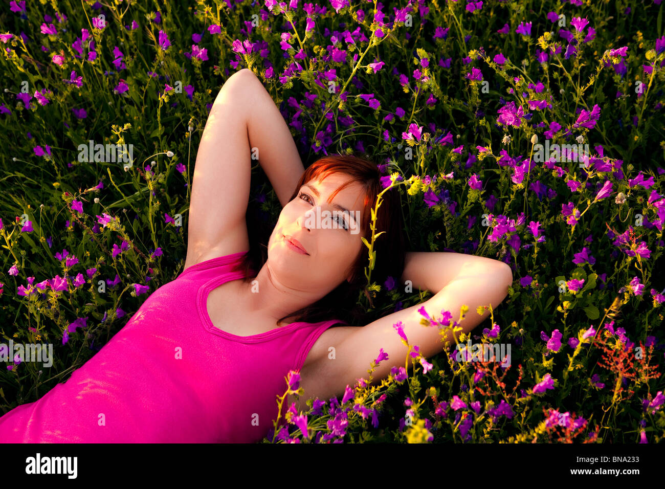 Vista dall'alto di una giovane e bella donna sdraiata su un prato fiorito Foto Stock