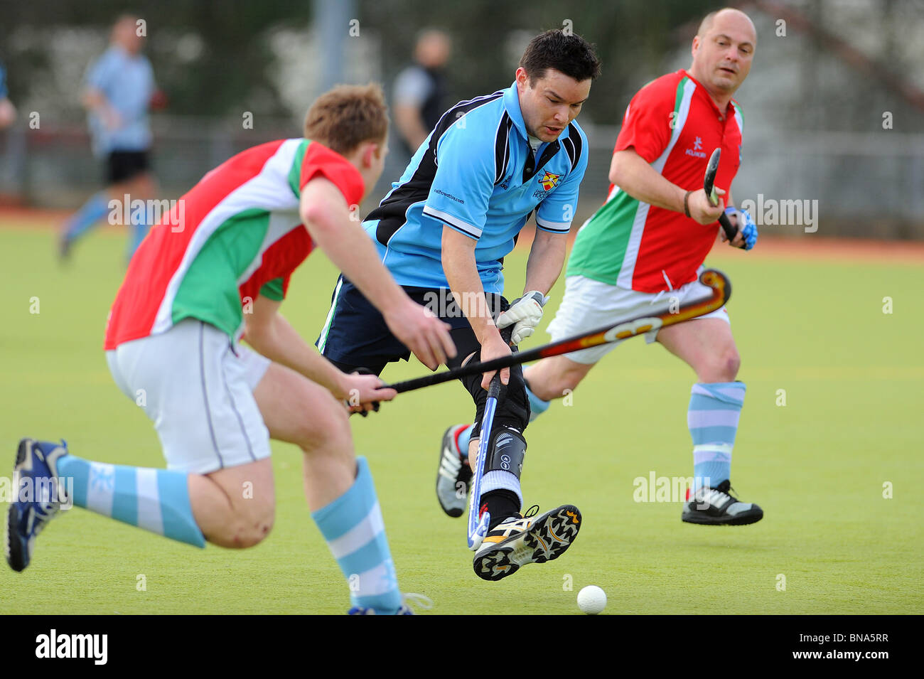 Un maschio di giocatore di hockey in azione su un astro turf pitch Foto Stock