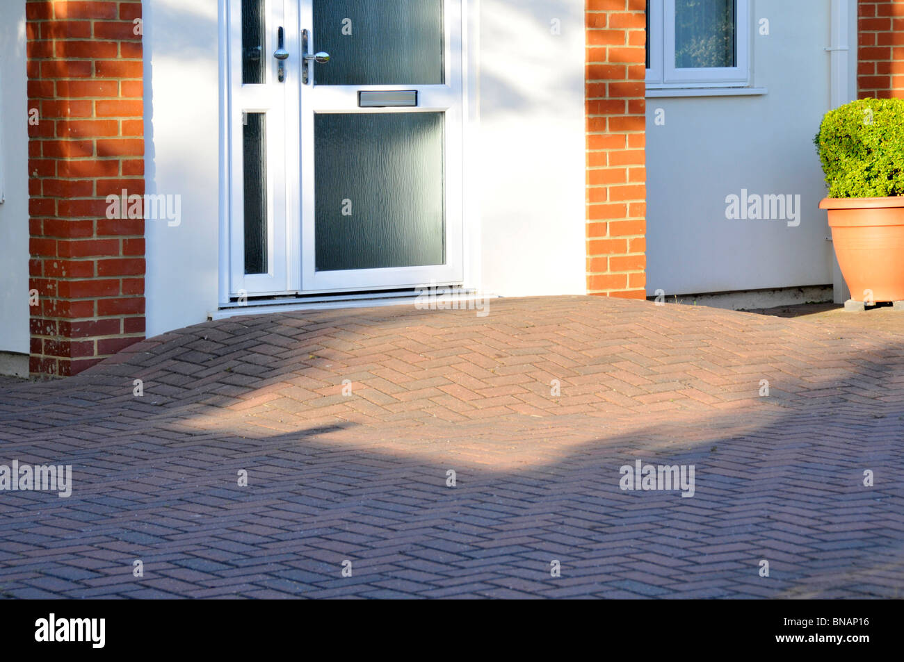 Il blocco di pavimentazione rampa di disabilità a casa porta anteriore dando passo libero accesso per disabili su sedia a rotelle Essex utente England Regno Unito Foto Stock