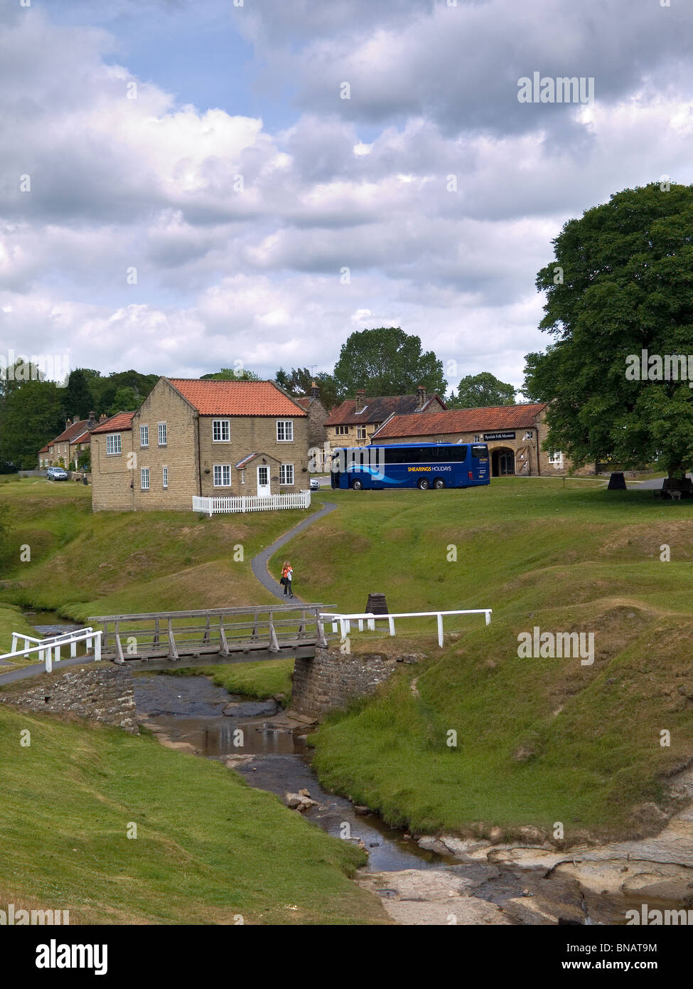 Il pittoresco villaggio di Hutton Le Hole North Yorkshire con un grande pullman turistico Foto Stock