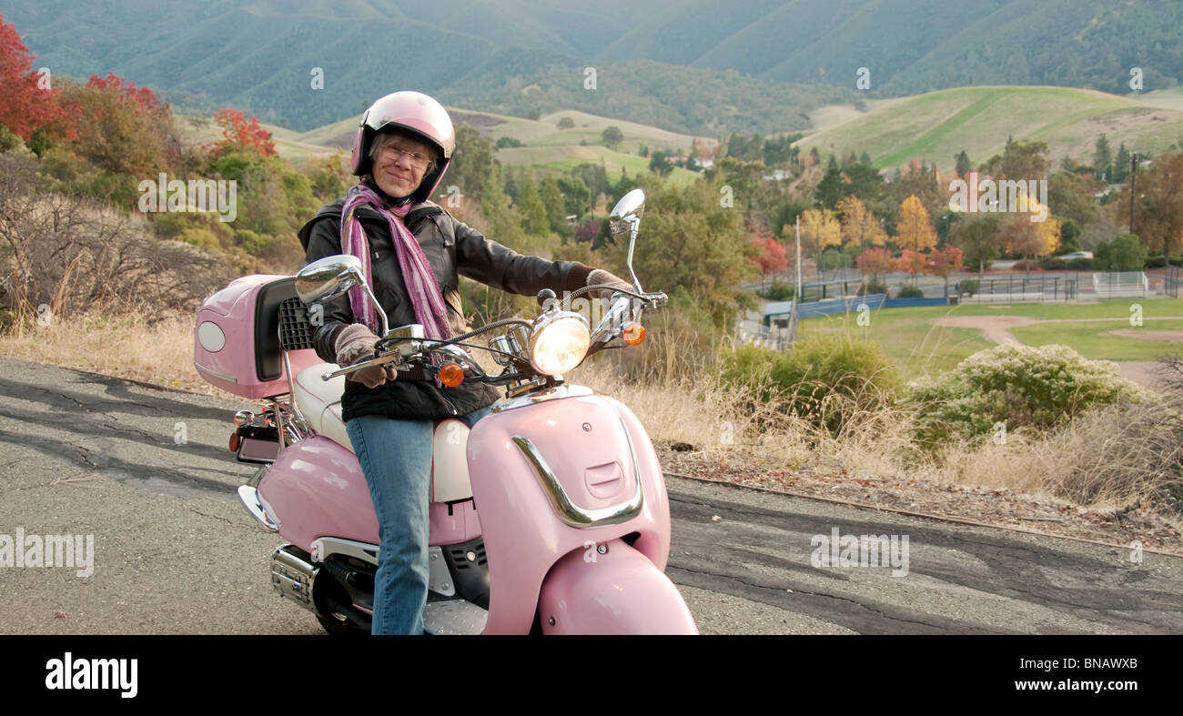 Sessanta anni di crociera biker giù una collina Foto Stock