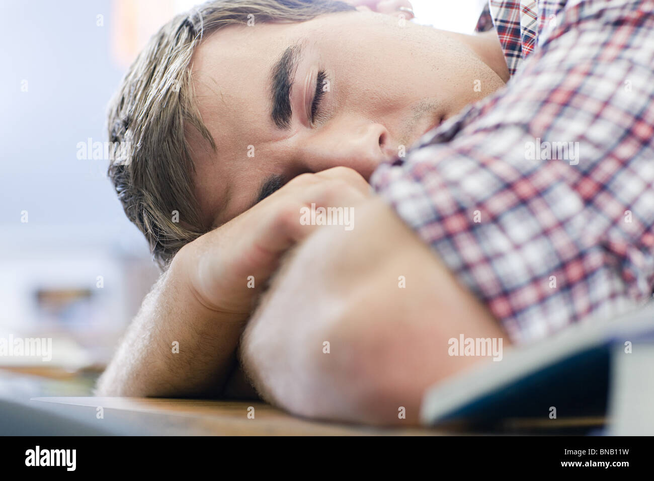 Maschio di alta scuola studente addormentato in classe Foto Stock