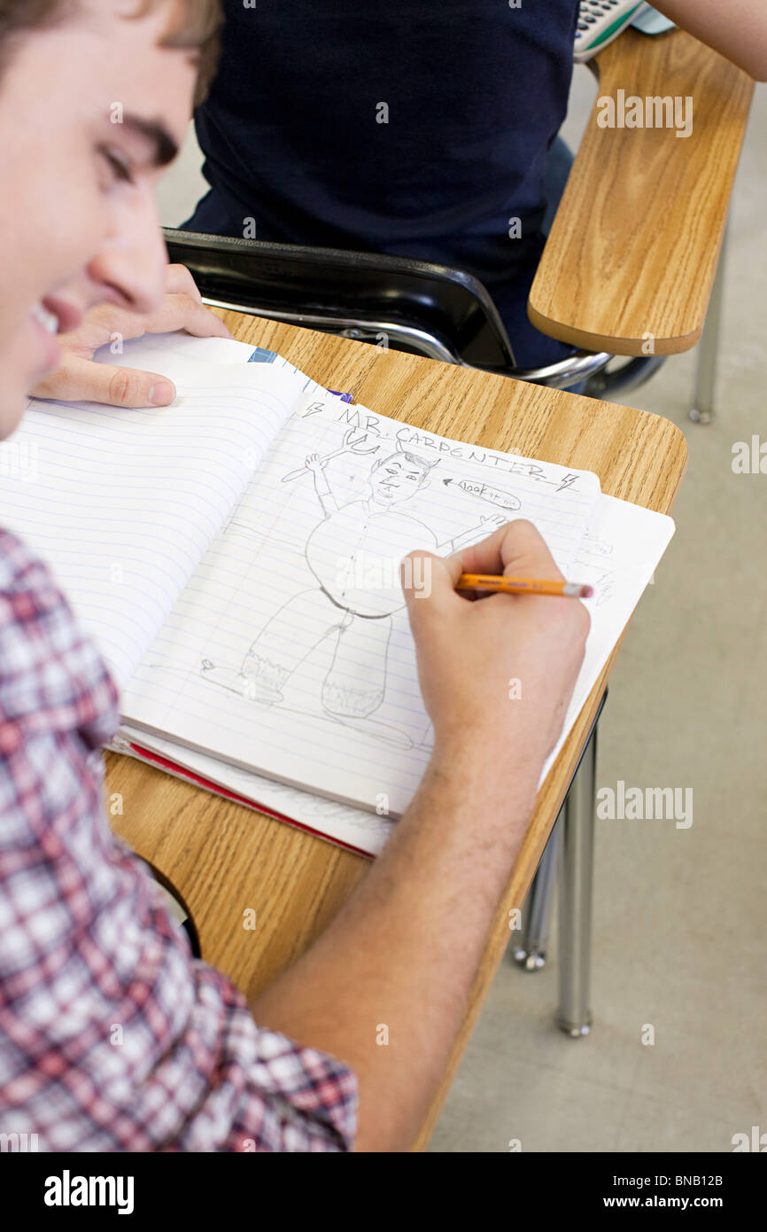 Maschio di alta scuola studente progettazione in notebook Foto Stock
