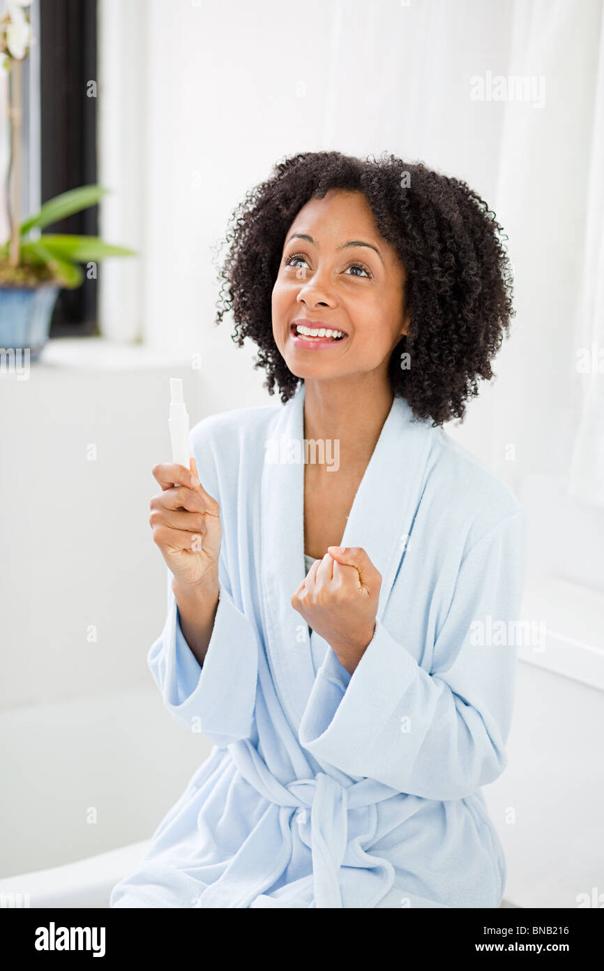 Donna gioisce per la gravidanza risultato del test Foto Stock
