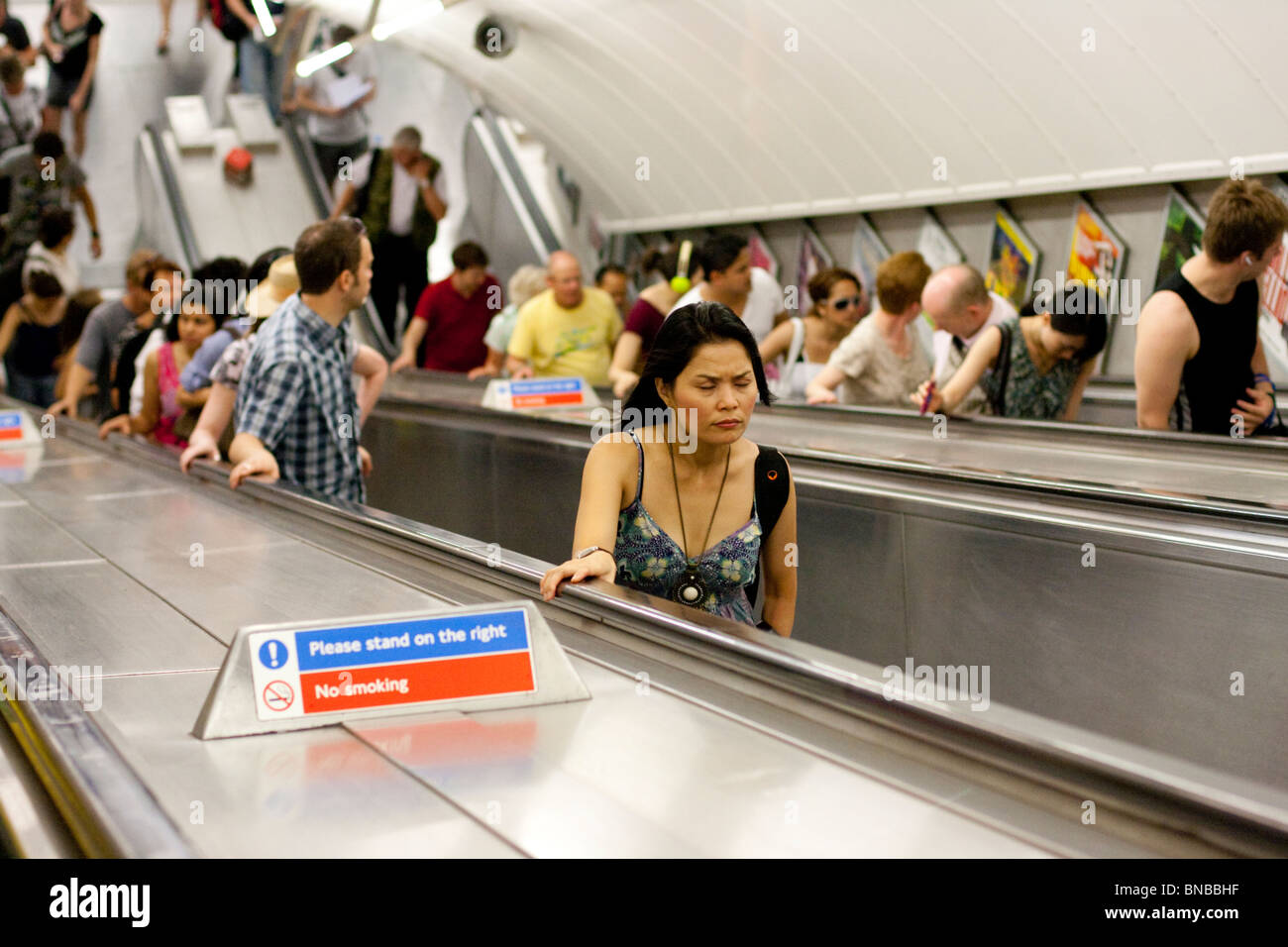 Pendolari su scale mobili, Stazione di Leicester Square, London, England, Regno Unito Foto Stock