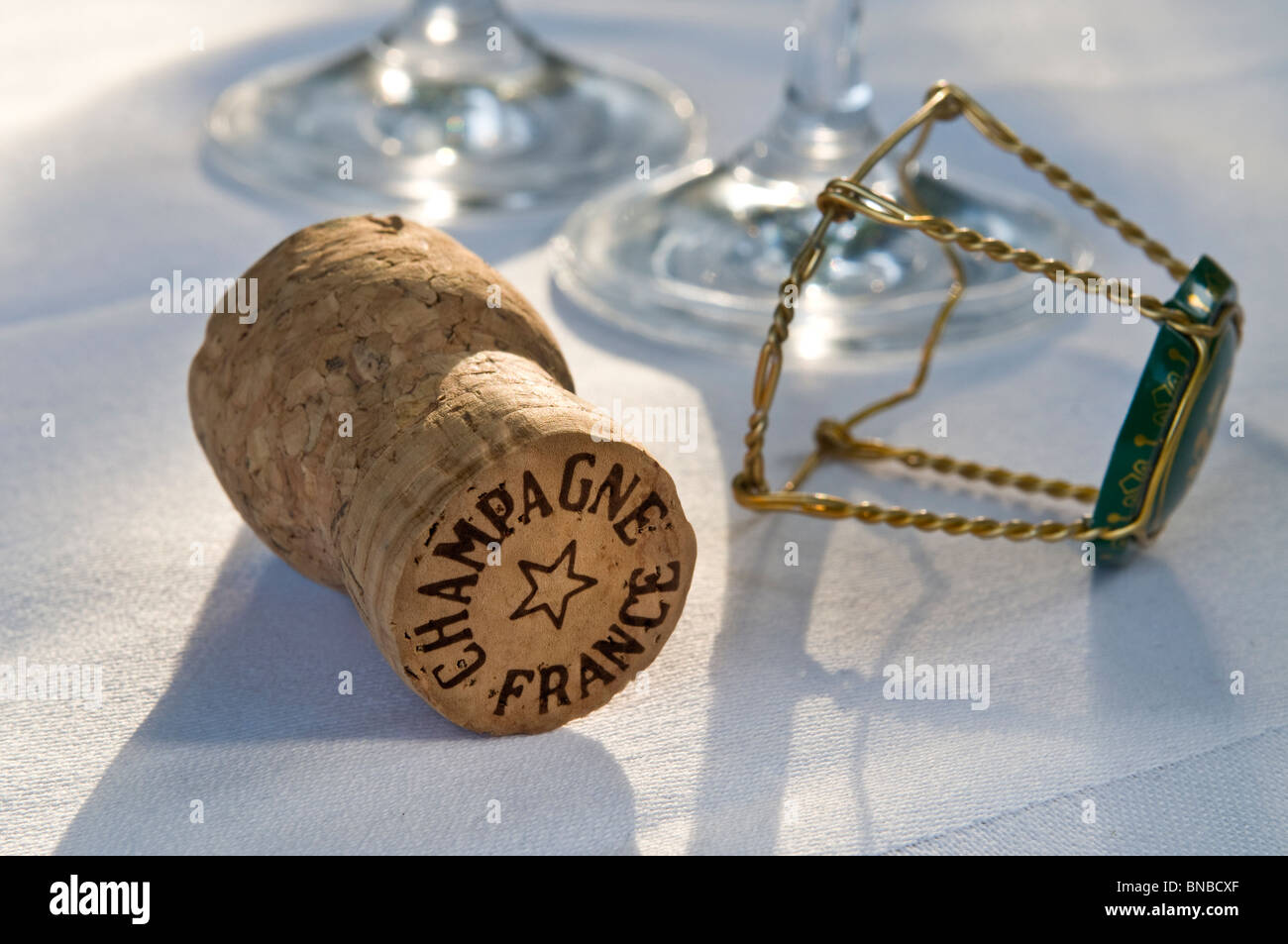 Tappo dello Champagne sulla tovaglia bianca con vetri a filo del telaio di fissaggio e il tappo Foto Stock
