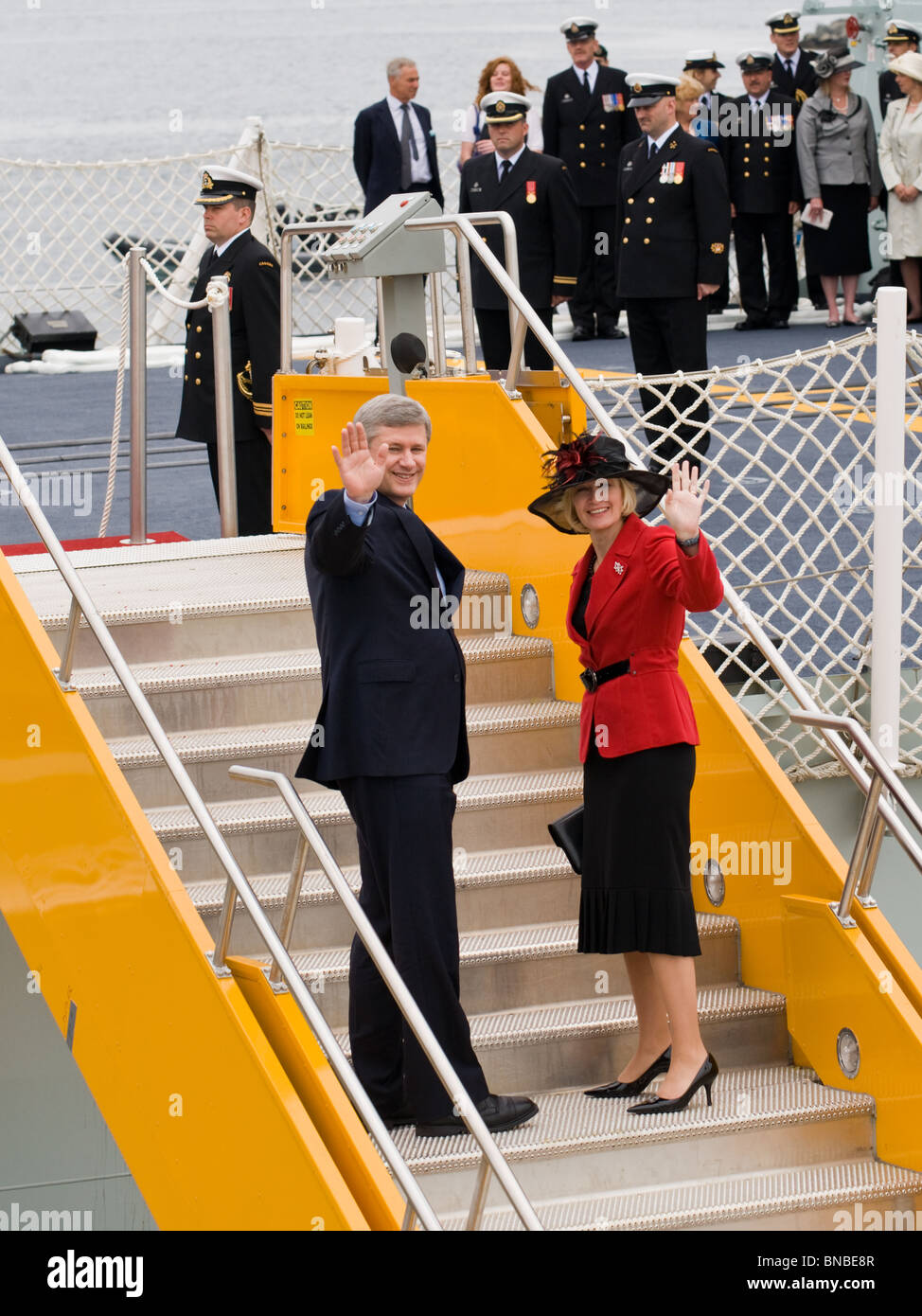 Il primo ministro Stephen Harper e sua moglie a onda media mentre imbarco HMCS ST. Giovanni a Halifax, NS. Foto Stock