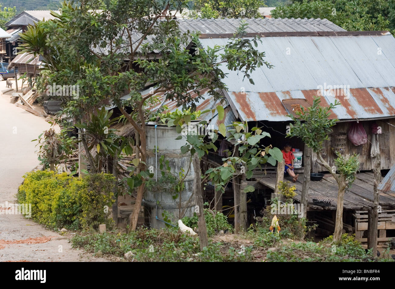 Ragazzo seduto fuori di casa sua, vietare la fino, Mae Hong Son Provincia, Thailandia Foto Stock