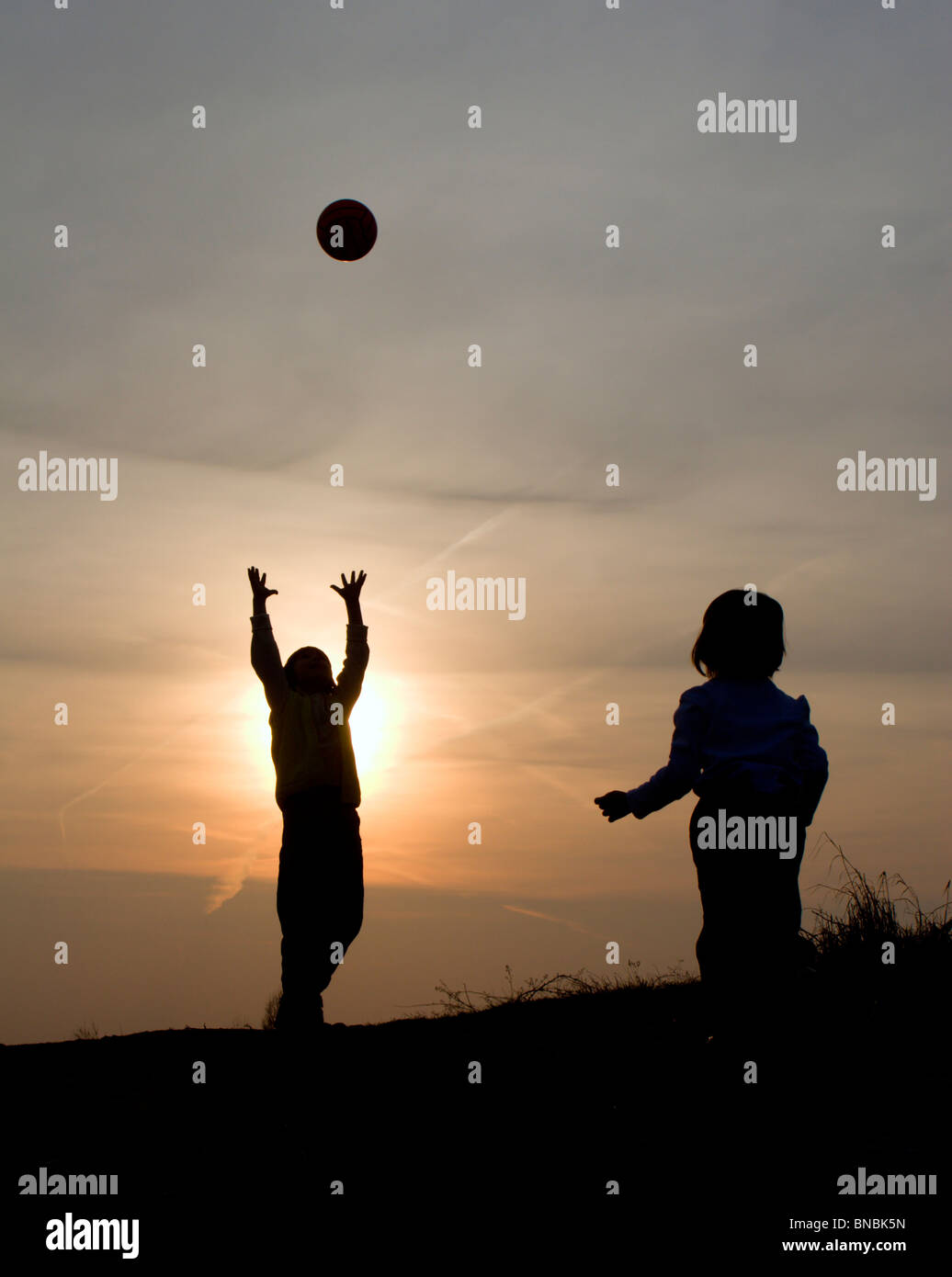 Gioca con la palla al tramonto - silhouette Foto Stock