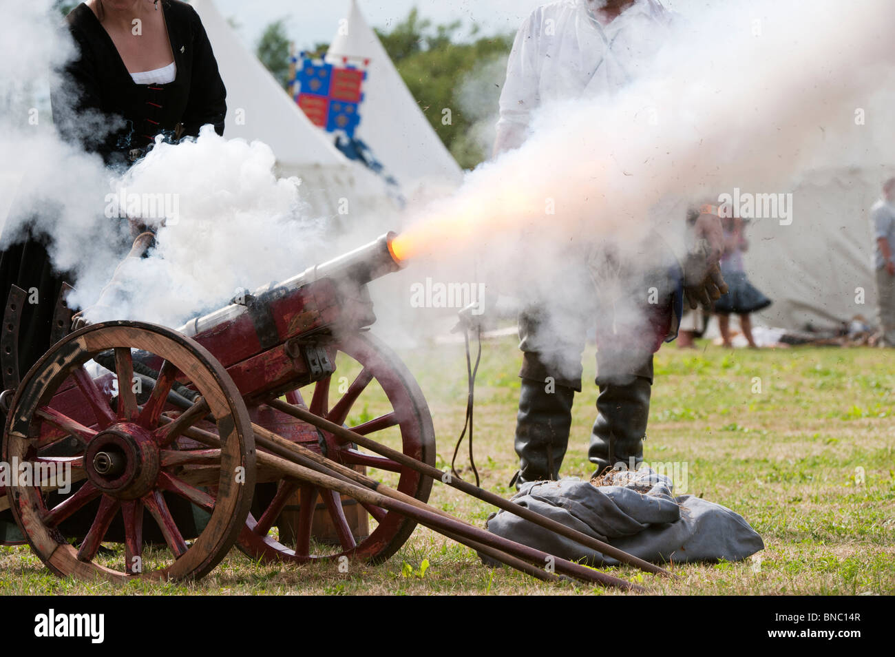 Donna medievale sparando un cannone a la rievocazione della battaglia di Tewkesbury. Un festival medievale 2010. Tewkesbury, nel Gloucestershire, Inghilterra Foto Stock