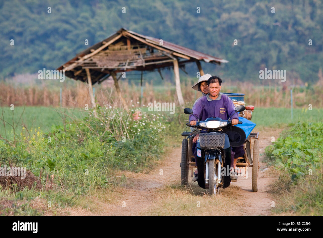 Un uomo e una donna su una bici in campagna, Tha Ton, Chiang Mai Provincia, Thailandia Foto Stock