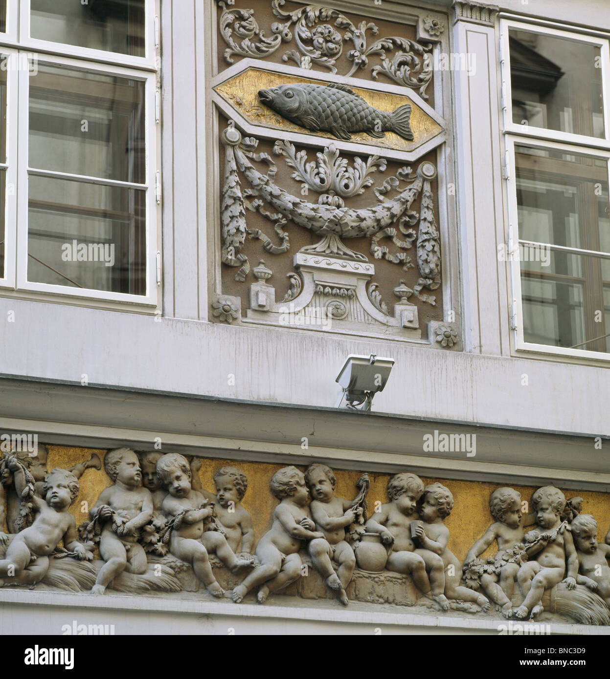 Fregio di putti e la placca di carpe, sulla casa del Blue Carp Annagasse. Vienna, Austria Foto Stock