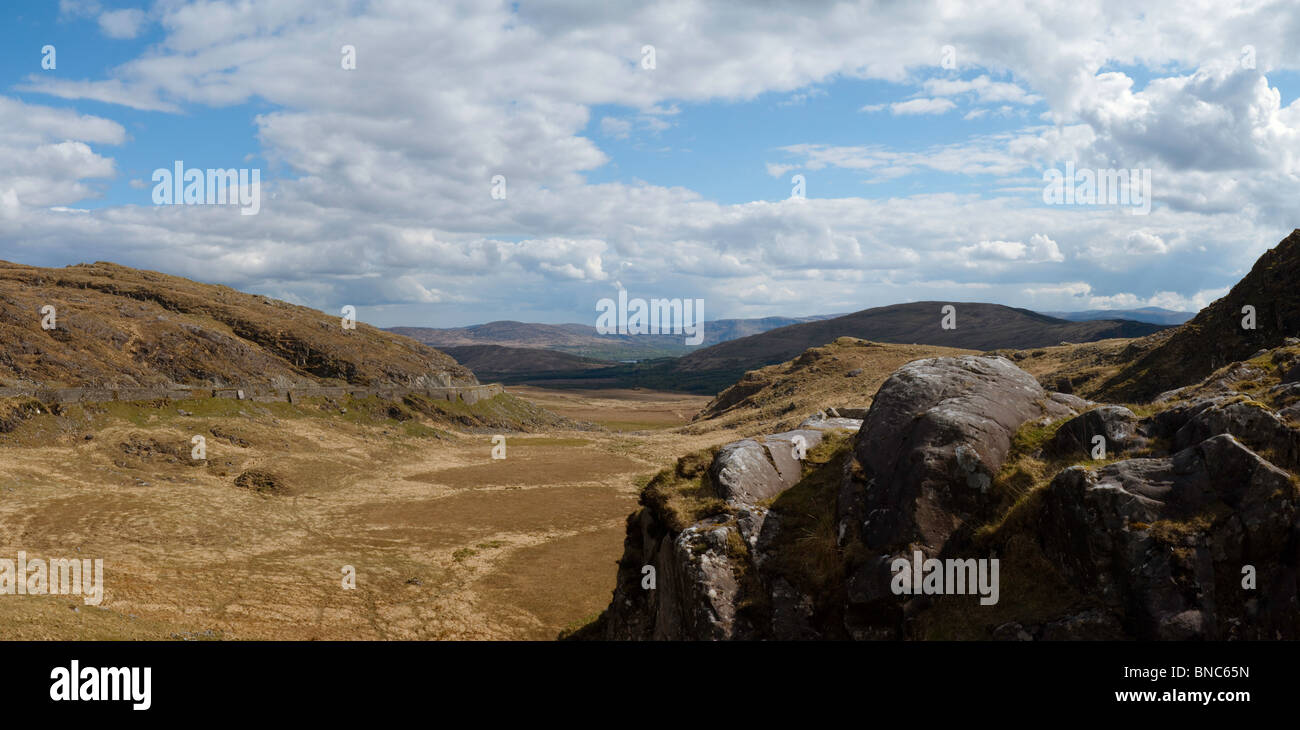 Dominik Moll Gap, Kenmare paesaggio. Guardando verso sud su roccia, un ampio paesaggio tra le montagne e con il cielo blu e nuvole sopra. Foto Stock