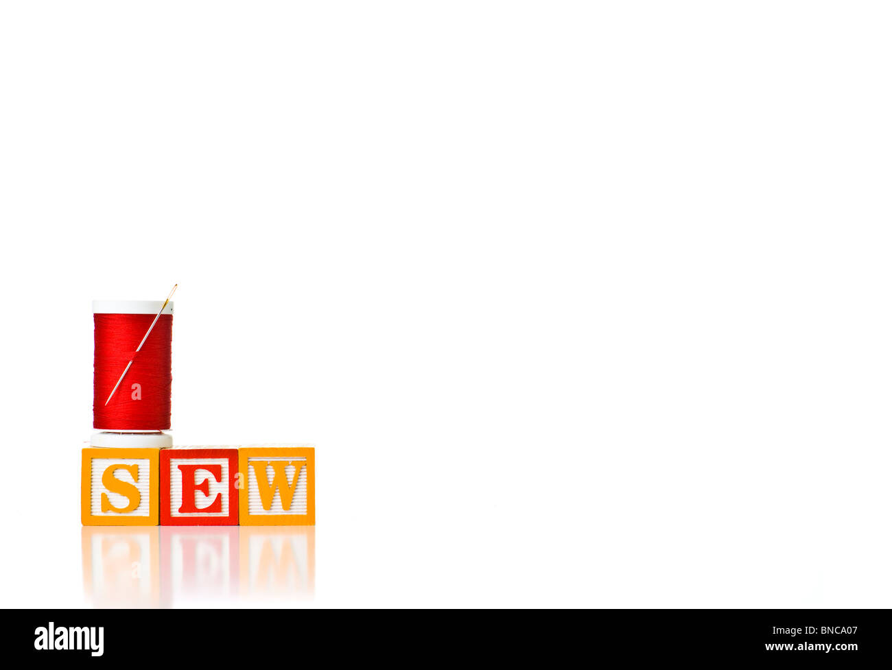 Colorata per bambini ortografia blocchi di cucire con un rocchetto di filo rosso Foto Stock