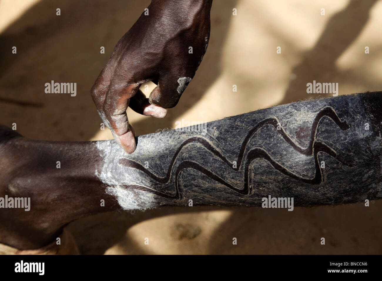 Tsemai l uomo è decorare le sue gambe con un gesso e dita, Etiopia Foto Stock