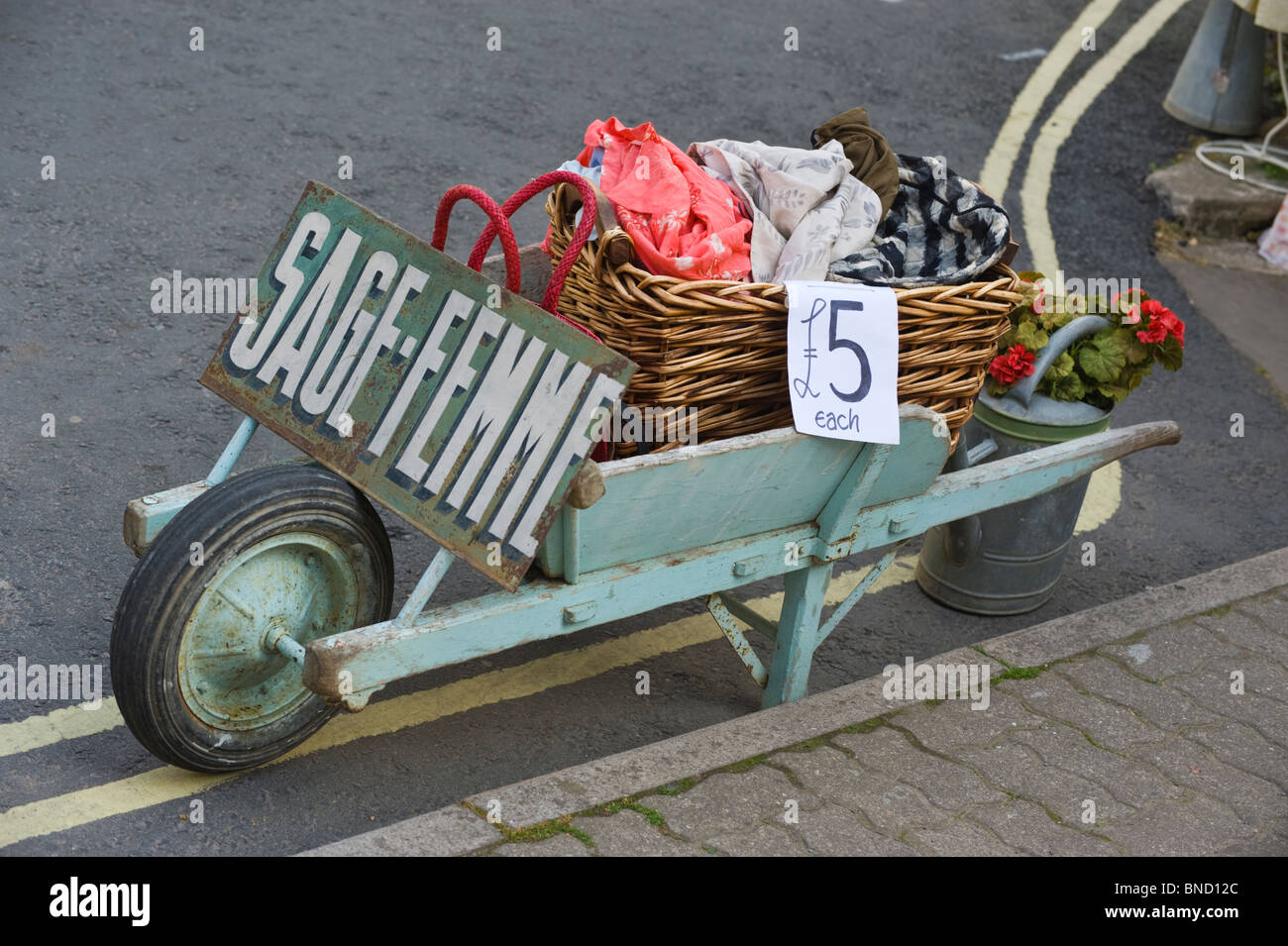 Carriola in legno con abbigliamento economici al di fuori del negozio in Hay-on-Wye Powys Wales UK Foto Stock
