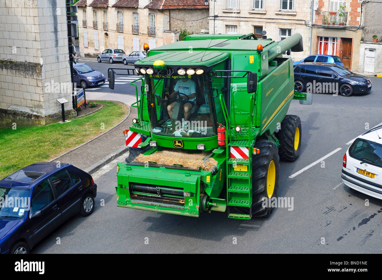 John Deere W540 mietitrebbia il traffico di negoziazione su strada pubblica - Francia. Foto Stock