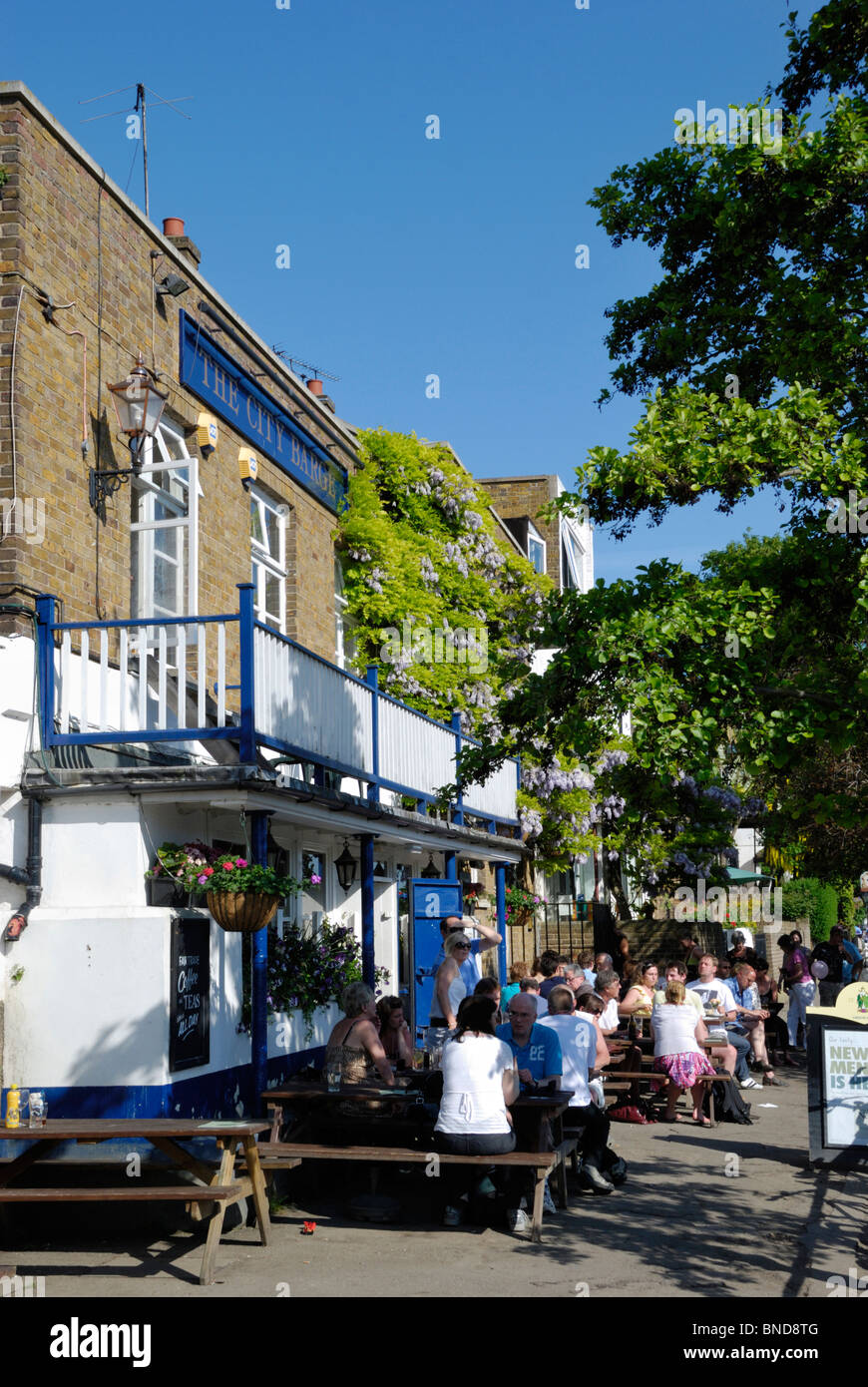 I clienti godendo il sole al di fuori della città Barge public house a trefolo sul verde, Chiswick, Londra, Inghilterra Foto Stock