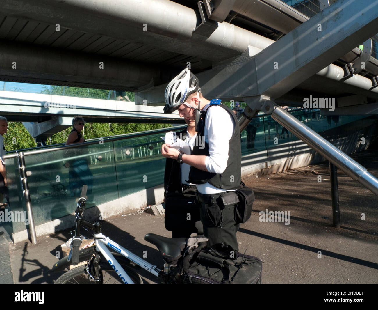 Il sostegno comunitario Officer esaminando i venditori di strada" sotto Licenza Millennium Bridge South Bank di Londra UK KATHY DEWITT Foto Stock