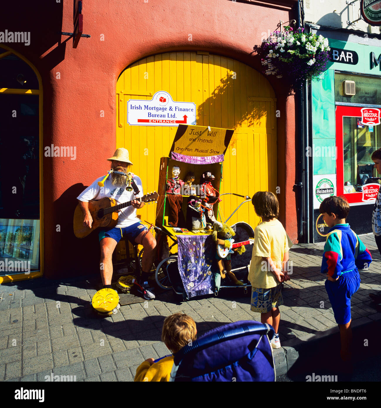 Bambini ascolto one-man band musicista, Westport, nella contea di Mayo, Repubblica di Irlanda, Europa Foto Stock
