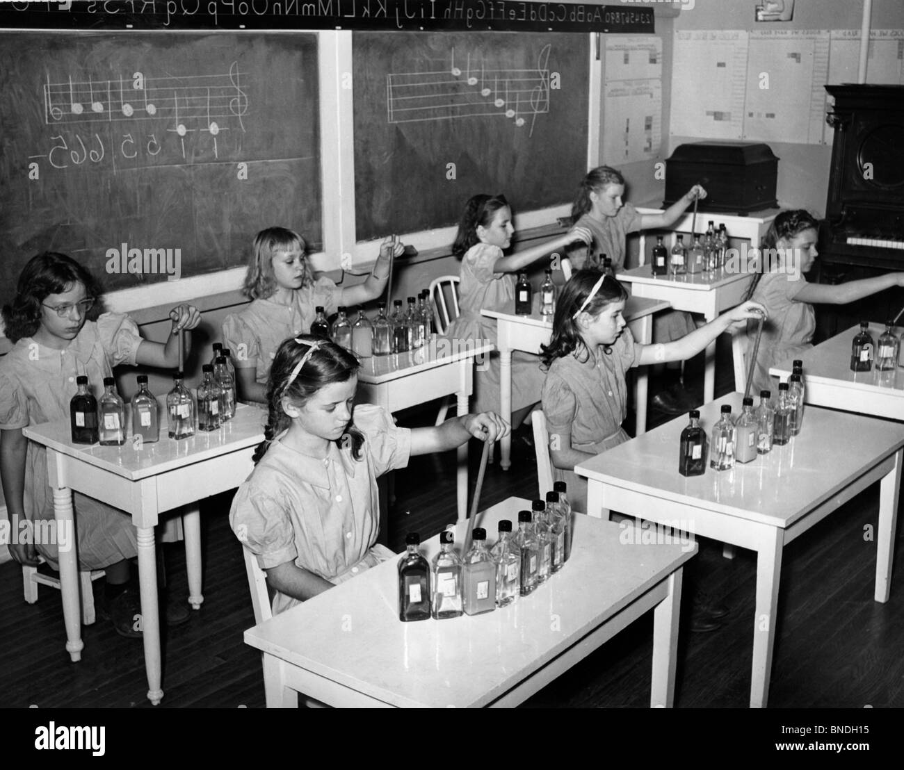 Un gruppo di ragazze della scuola seduto in una classe di musica Foto Stock