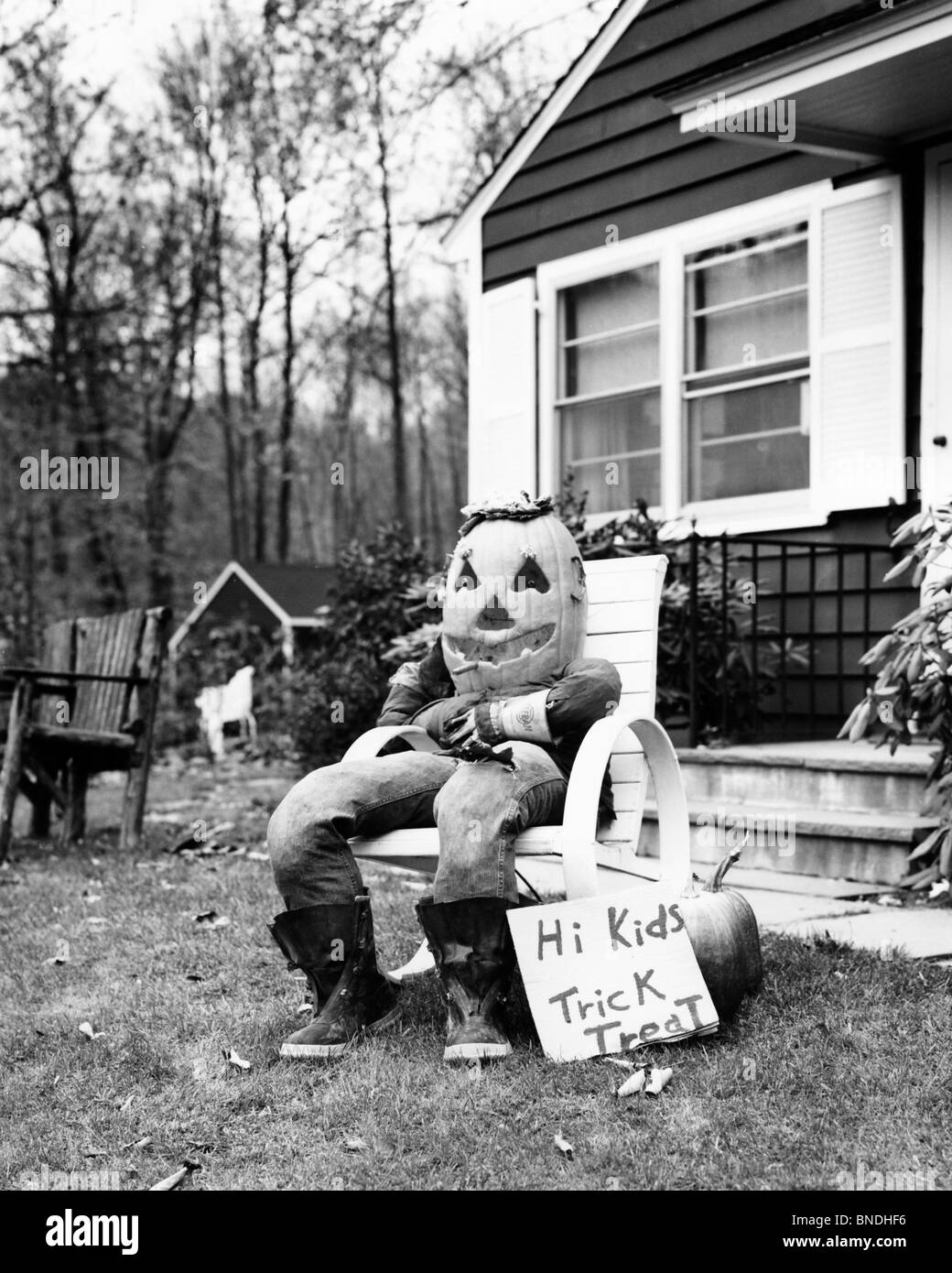 Lo Spaventapasseri in un costume di Halloween seduto in poltrona di fronte a una casa Foto Stock