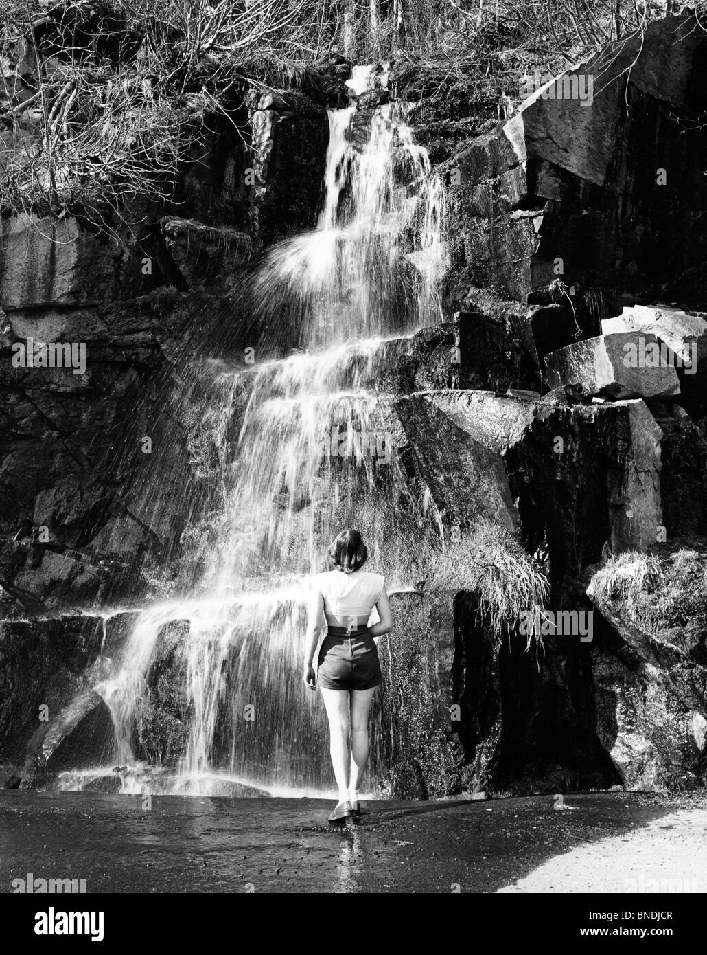 Stati Uniti d'America, nello Stato di Washington, il Parco Nazionale di Olympic, donna in piedi vicino a cascata Foto Stock