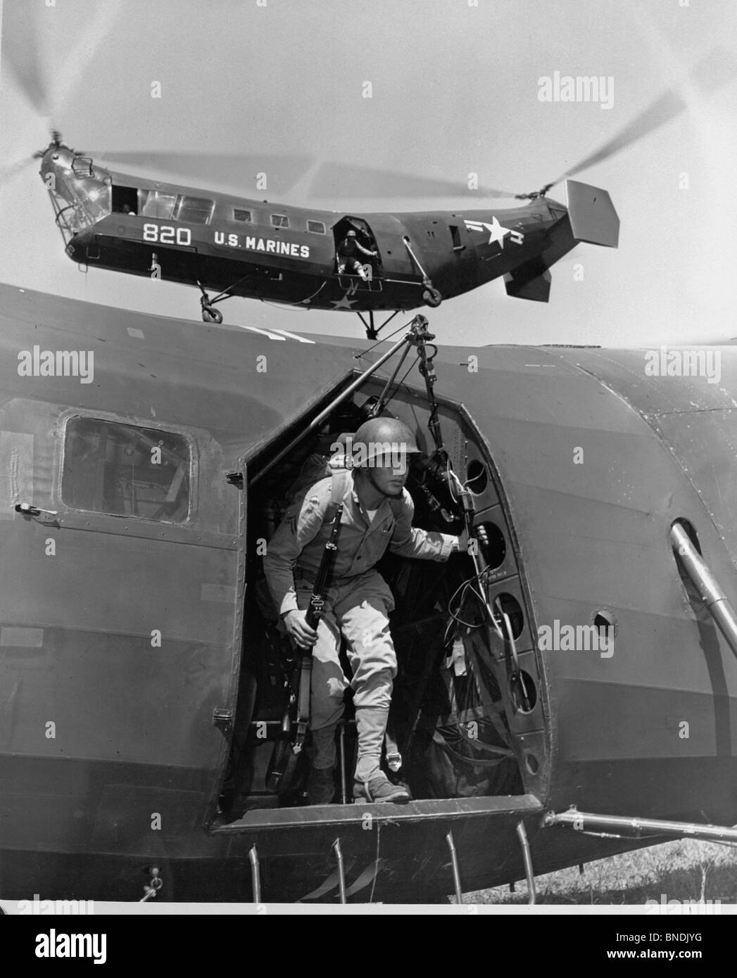Soldato dell'esercito si prepara a sbarcare da un elicottero, US Marine Corps Foto Stock