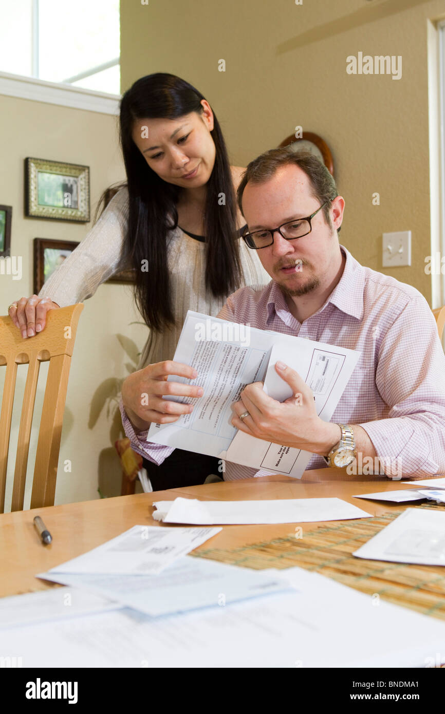 Japanese-American moglie e marito Mexican-American compilare loro 2010 Stati Uniti Censimento forma nella loro casa di Austin, Texas. Foto Stock