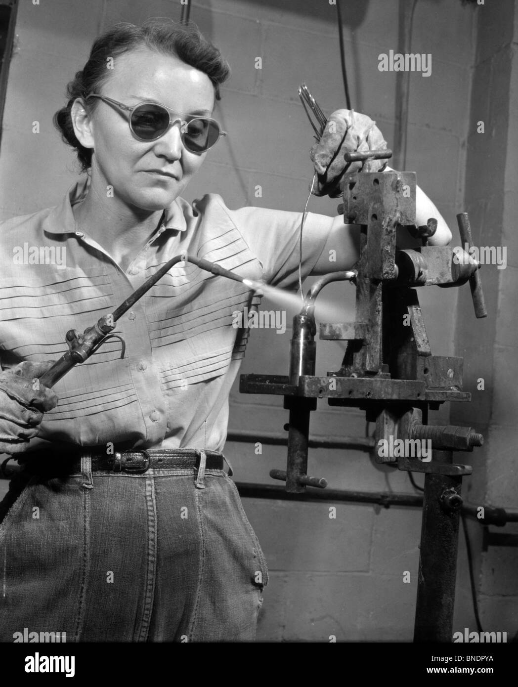 Basso angolo di visione di un saldatore femmina di saldatura con una torcia di saldatura Foto Stock