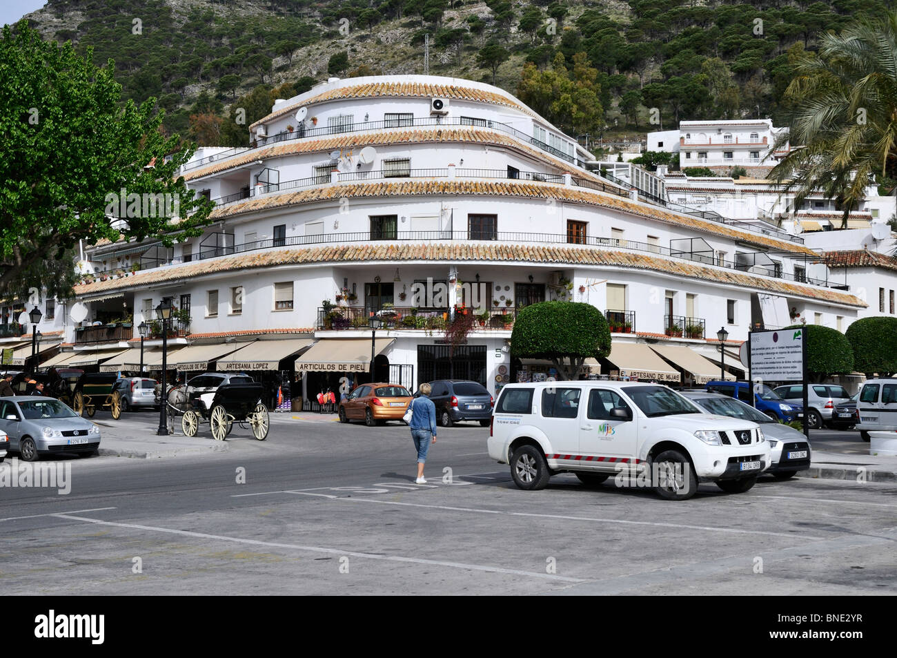 Un attraente complesso turistico a livello di strada di negozi con appartamenti e monolocali che si eleva al di sopra del villaggio bianco di Mijas Foto Stock