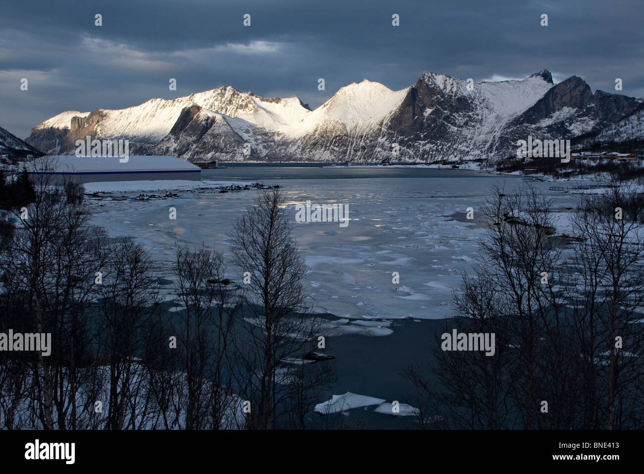 Mefjordbotn pesca costiera borgo incastonato tra le montagne senja inverno artico Norvegia Foto Stock