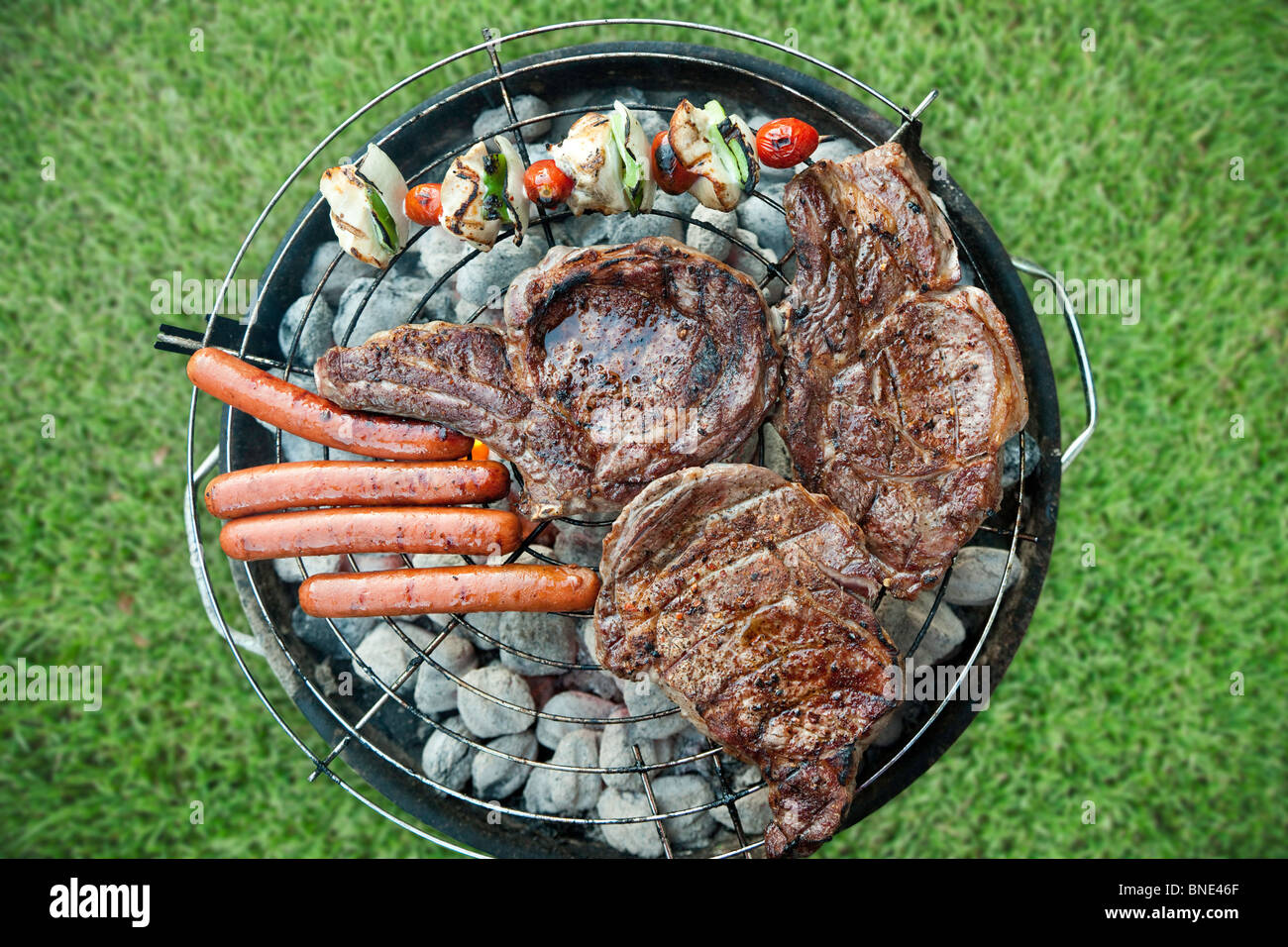 Carne, hot dogs e verdura sul barbecue Foto Stock