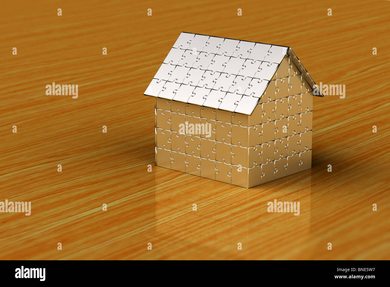 Casa fatta di pezzi di un puzzle su una superficie di legno Foto Stock