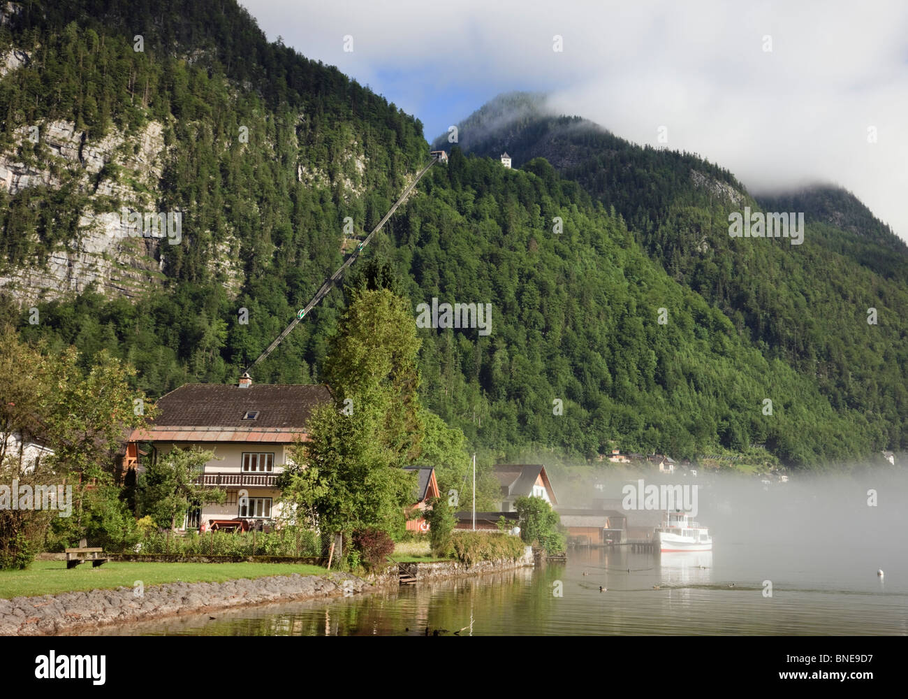 Hallstatt, Salzkammergut, Austria. Vista del lago Hallstattersee con nebbia di mattina in aumento e Salzberg funicolare Foto Stock