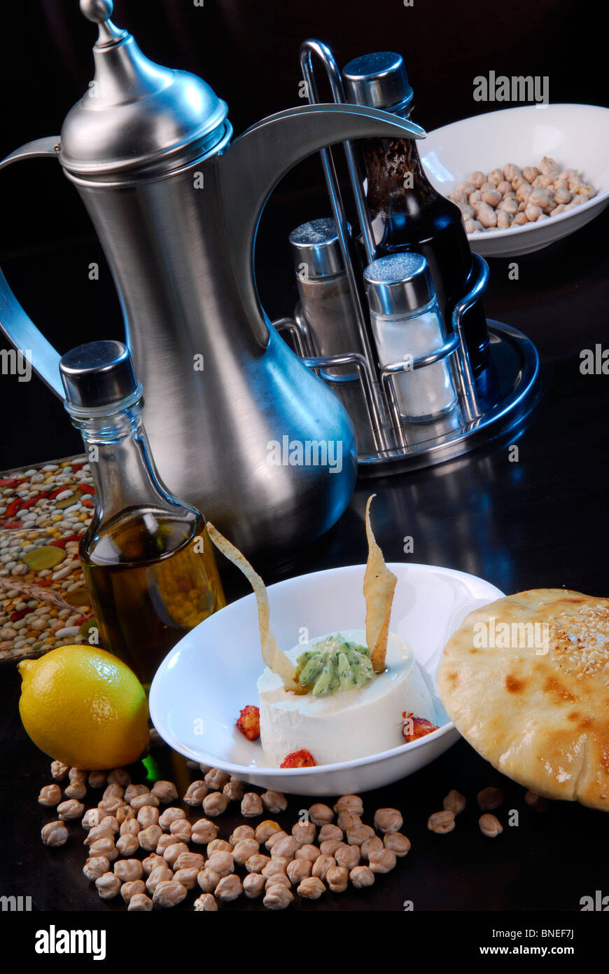 Cibo arabo humus,disposti con bollitore tradizionale,l'olio d'oliva e piselli. Foto Stock