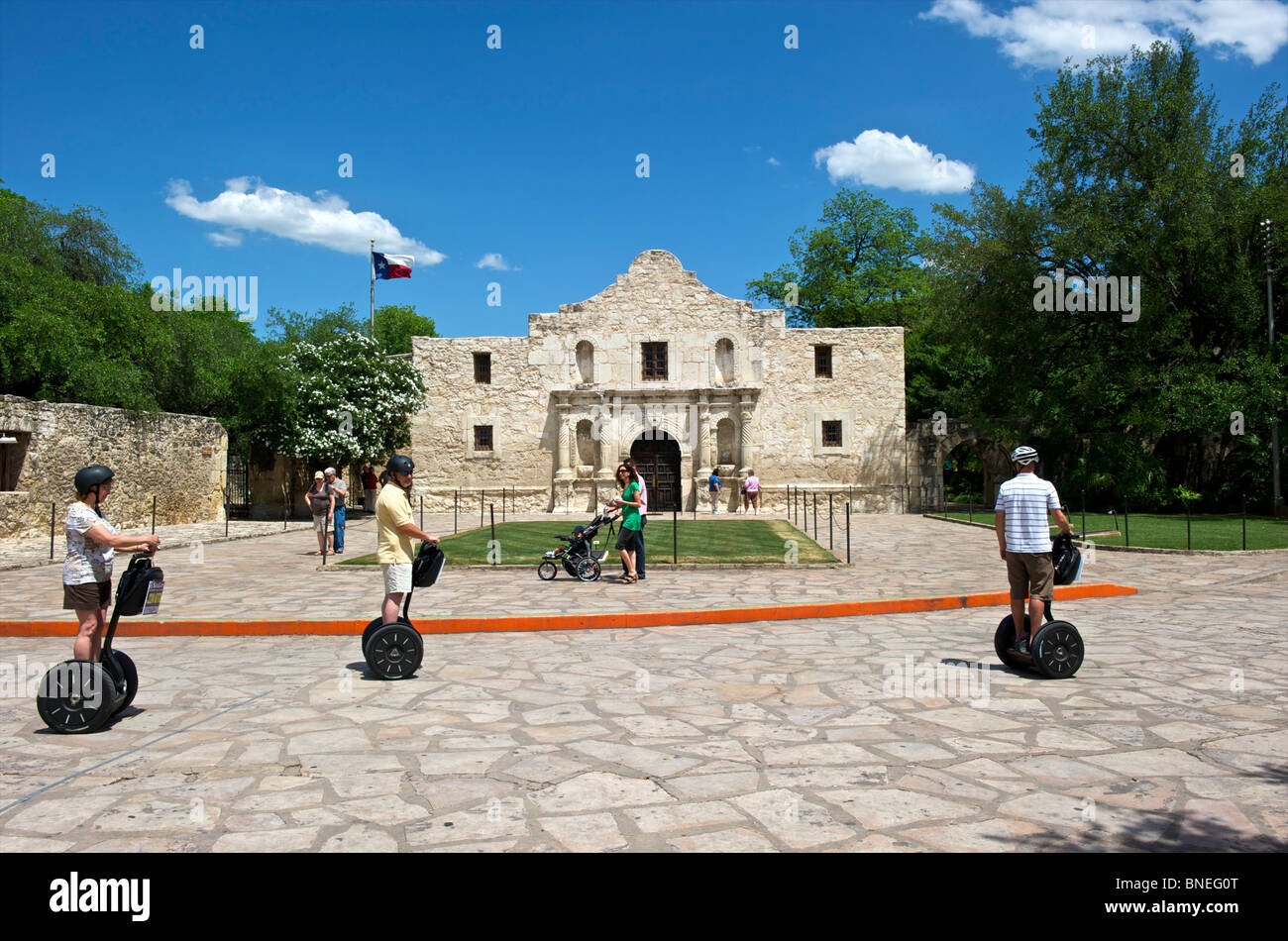 I turisti e i turisti su segways alla missione di Alamo, simbolo di indipendenza del Texas di San Antonio, Texas, Stati Uniti d'America Foto Stock