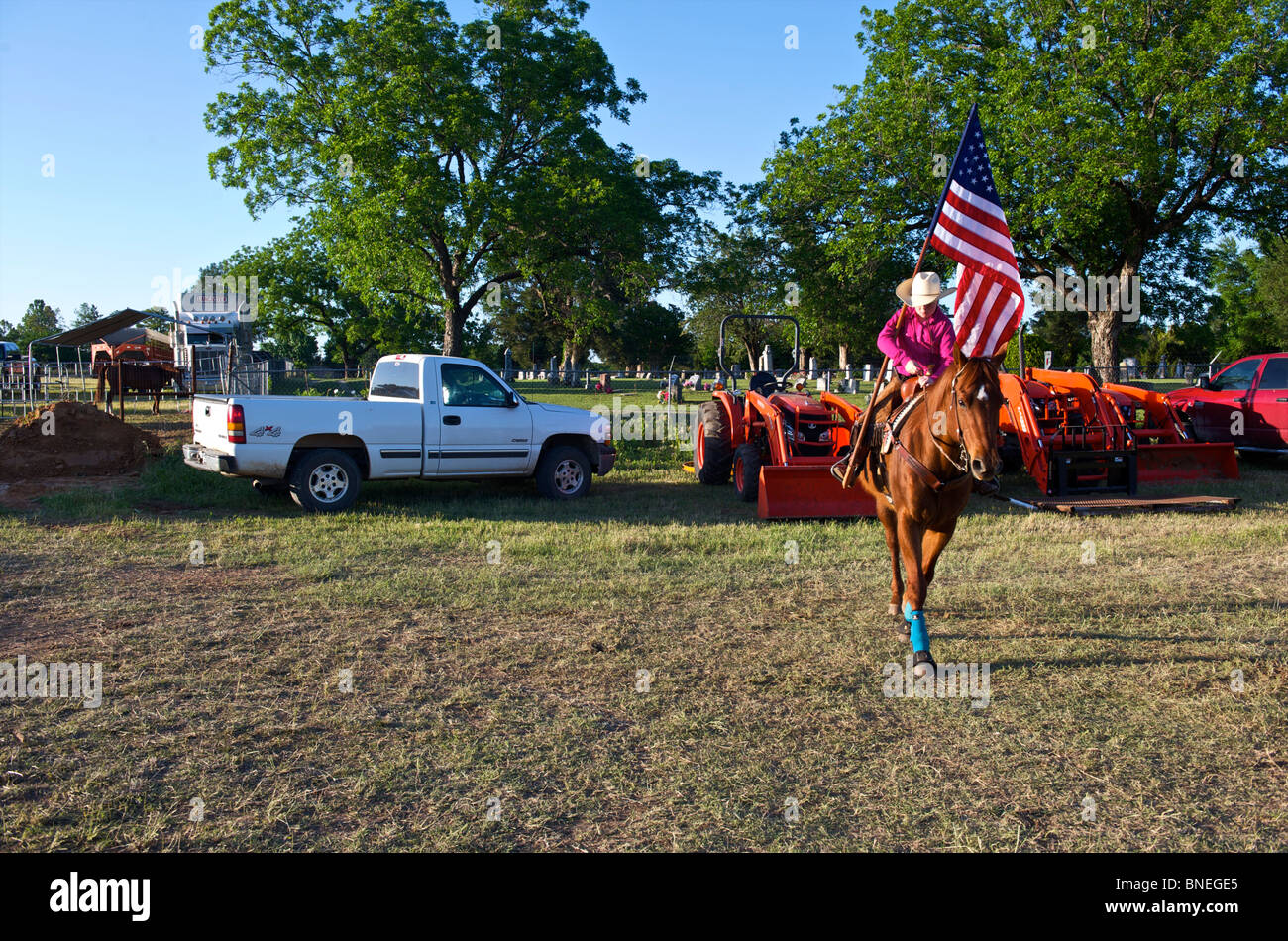 Cowgirl sventola bandiera nel piazzale di stoccaggio prima della cerimonia di apertura di PRCA Rodeo evento in Texas, Stati Uniti d'America Foto Stock