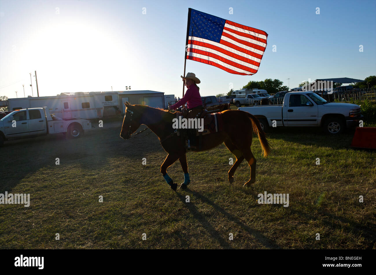 Cowgirl sventola bandiera americana alla cerimonia di apertura di PRCA Rodeo evento in Texas, Stati Uniti d'America Foto Stock