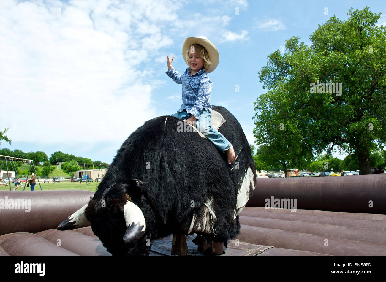 Cowboy cercando la sua fortuna a rimanere sul toro meccanico Foto Stock