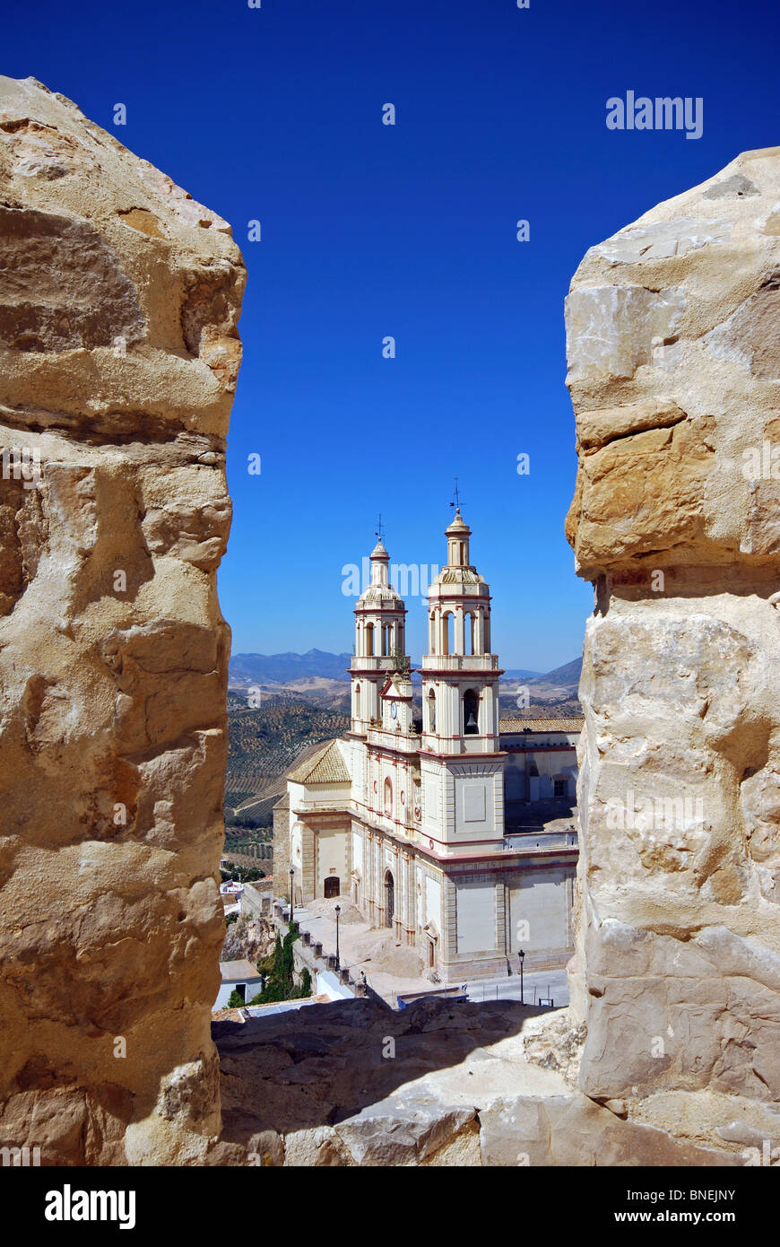 Chiesa parrocchiale di Nostra Signora di La Encarnacion visto attraverso i merli del castello, Olvera, la provincia di Cadiz Cadice, Andalusia, Spagna, Europa. Foto Stock