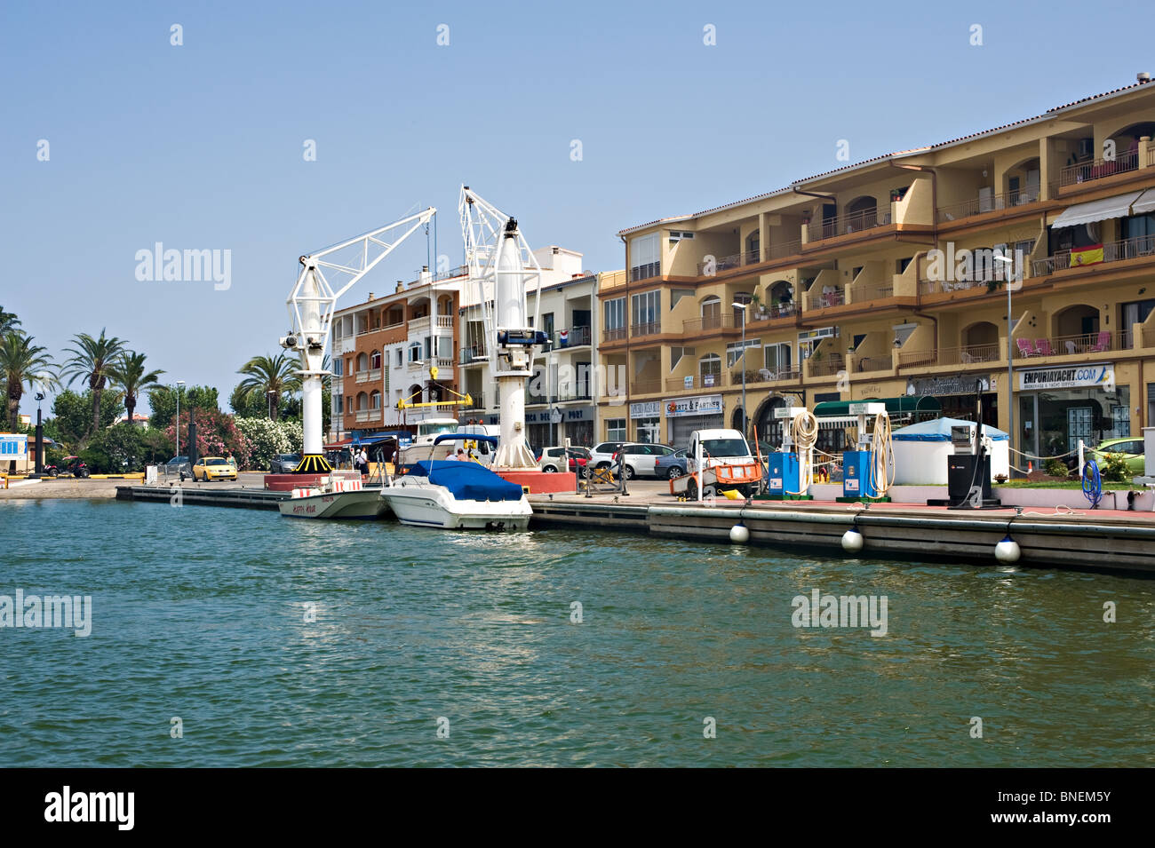 Fase di atterraggio e barca paranco gru sulla rete dei canali a Empuriabrava con blocchi di appartamenti e uffici Costa Brava Spagna Espana Foto Stock